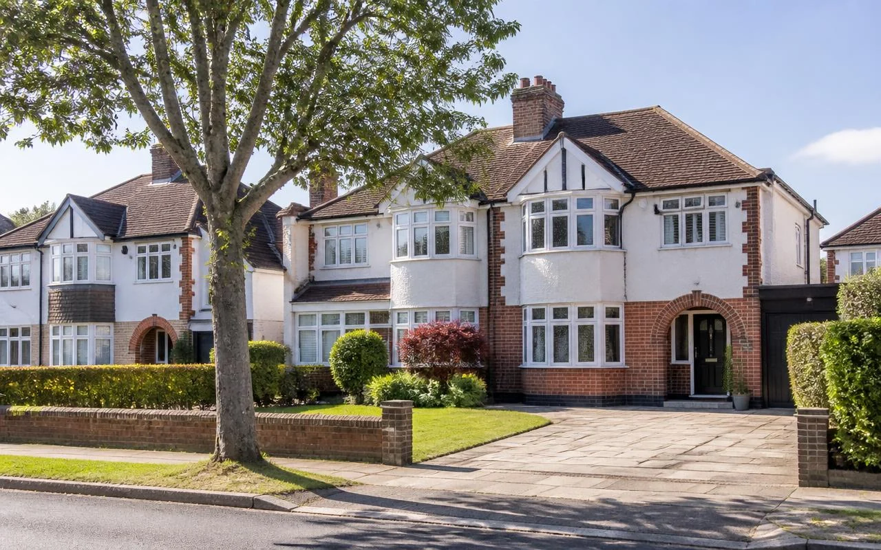 Suburban semi-detached houses with neat lawns on a tree-lined street in Essex