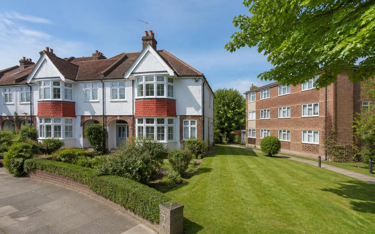 Suburban semi-detached houses and a low-rise block with communal lawn in Greater London